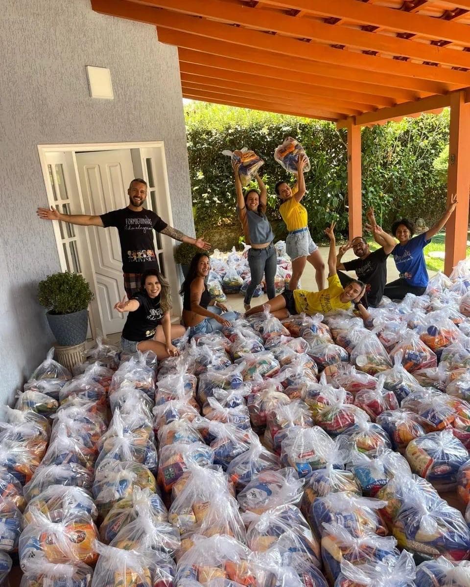 Voluntários entregando cestas básicas para famílias
